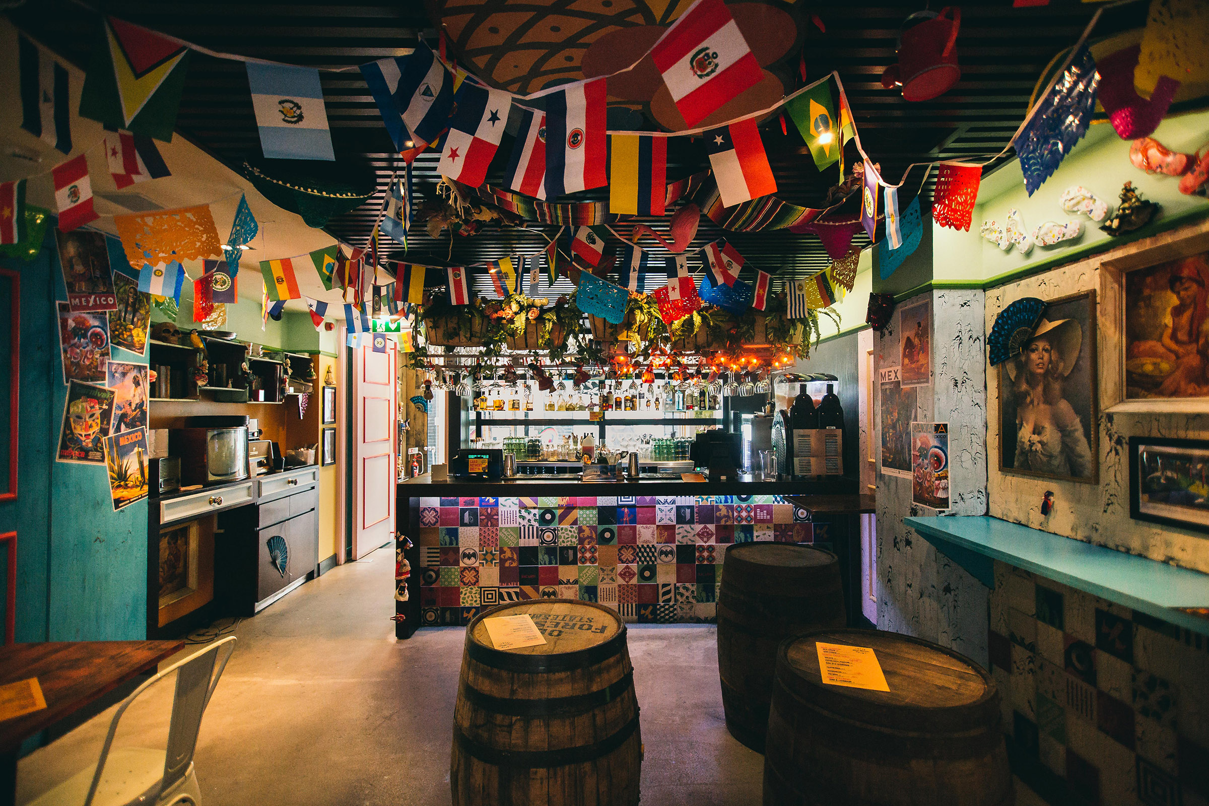 Casa Bonita pop-up bar in London. Eclectic interior with hanging flags and coloured walls designed by CT Creative